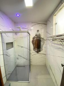 a shower with a glass door in a bathroom at Na Trilha da Ostra 2 - Brechó e Antiquário in Brumadinho
