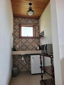 a small kitchen with a refrigerator and a window at Na Trilha da Ostra 2 - Brechó e Antiquário in Brumadinho +17 photos