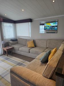 a living room with a couch and a tv at Sunflower 62 Braunton in Ashford