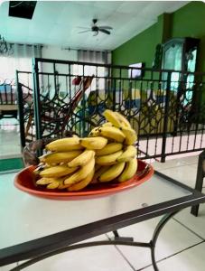 a bunch of bananas on a red plate on a table at Casa Hogar in Ahuachapán