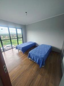a room with two beds and a large window at Triplex con vista hermosa in Salta