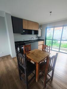 a kitchen with a wooden table and some chairs at Triplex con vista hermosa in Salta