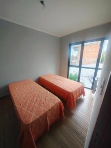 two beds in a room with a window at Triplex con vista hermosa in Salta +7 photos