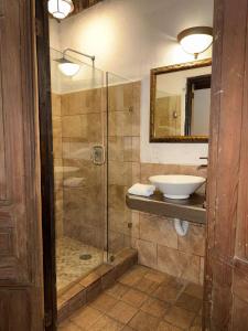 a bathroom with a glass shower and a sink at Hotel Ruinas Del Real in Real de Catorce