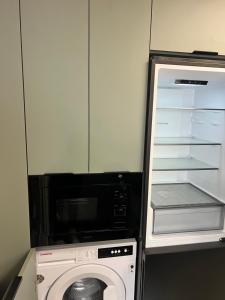a kitchen with a microwave and a washing machine at La Casita in Ardales