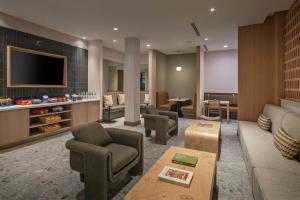 a living room with a couch and chairs and a tv at Albuquerque Marriott Pyramid North in Albuquerque