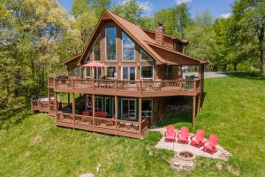 a large house with red chairs in the grass at The Cozy Perch by Railey Vacations in Oakland
