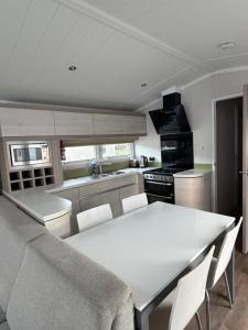 a kitchen with a white table and chairs in it at RelaxDream in Port Seton
