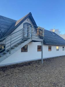 a white building with a staircase on the side of it at Lysbjerggård Bed & Break Herning in Herning