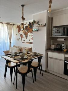 a table and chairs in a living room with a kitchen at Apartment steps away from the beach in La Serena