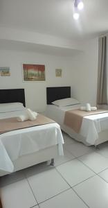 two beds in a room with white walls at Apartamento Completo 608 Monte Fuji, Praia de Cabo Branco in João Pessoa +49 photos