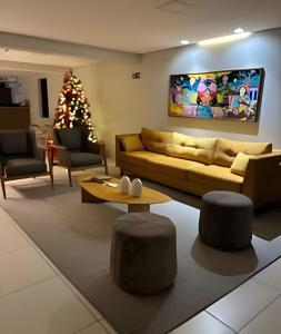 a living room with a couch and a christmas tree at Apartamento Completo 608 Monte Fuji, Praia de Cabo Branco in João Pessoa