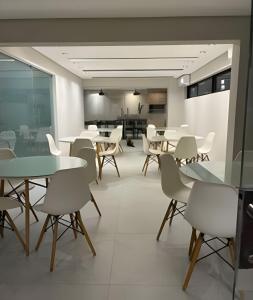 a dining room with tables and white chairs at Apartamento Completo 608 Monte Fuji, Praia de Cabo Branco in João Pessoa