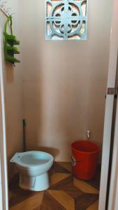 a bathroom with a toilet and a bucket at Macabuag Apartment in Narra