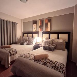 a bedroom with two beds with cheetah pillows at Hotel Hacienda Entabladero in Entabladero