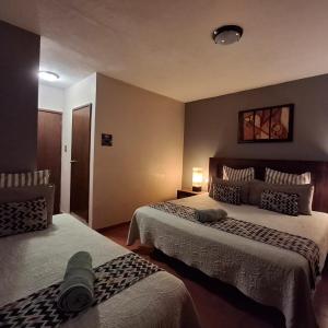 a hotel room with two beds in a room at Hotel Hacienda Entabladero in Entabladero