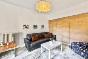 a living room with a black leather couch and a table at Lenno Centrale in Lenno
