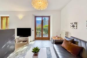 a living room with a couch and a tv at Lenno Centrale in Lenno