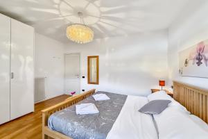 a bedroom with a bed and a chandelier at Lenno Centrale in Lenno +16 photos