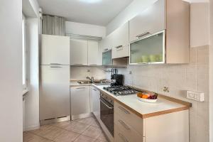 a kitchen with white cabinets and a white refrigerator at Residenza Menaggio - Mimosa in Menaggio +19 photos
