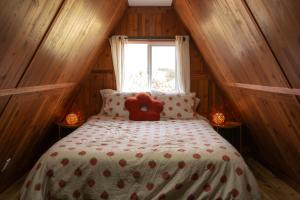 a teddy bear sitting on a bed in a room at The Cozy Owl A-Frame in Jefferson