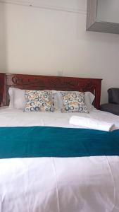a large bed with blue and white sheets and pillows at Franliz Apartments in Nairobi