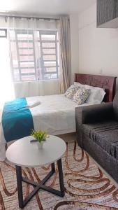 a living room with a bed and a coffee table at Franliz Apartments in Nairobi