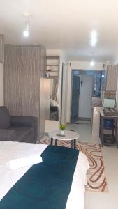 a room with a bed and a table and a couch at Franliz Apartments in Nairobi