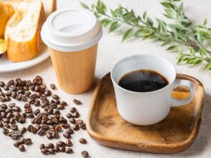 a cup of coffee on a tray with coffee beans at APA Hotel Shinjuku Kabukicho Tower in Tokyo