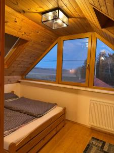 a bedroom with a bed in a room with windows at L&B Home in Pravonín