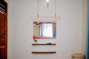 a mirror on a wall next to a window at Roots and Waves in Zanzibar City