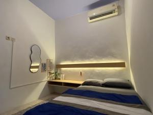 a small bedroom with a bed and a wall at La Via Living in Sukobumi