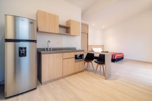 a kitchen with a stainless steel refrigerator and a table at Hotel Estar in Manizales
