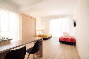 a room with two beds and a desk and chairs at Hotel Estar in Manizales +12 photos