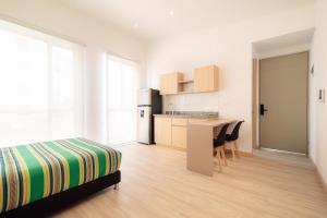 a white room with a bed and a kitchen at Hotel Estar in Manizales