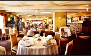 a dining room with white tables and chairs at Private Apartments in Hotel Snezhanka in Pamporovo
