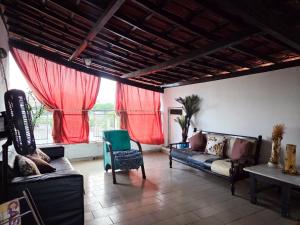 a living room with two couches and red curtains at Vila Mariah Hostel in Belo Horizonte