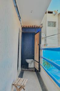 a bathroom with a toilet and a wooden door at Chiwash Place Taghazout in Taghazout