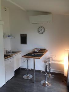 a kitchen with a counter and a clock on the wall at Chambre d'Hôtes du Clos Bamboo in Mérignac +37 photos