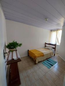 a bedroom with a bed and a table in it at Pousada recanto das ondas in Macaé