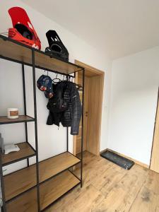a room with a shelf with a helmet and jackets at Apartmán Buky in Mladé Buky