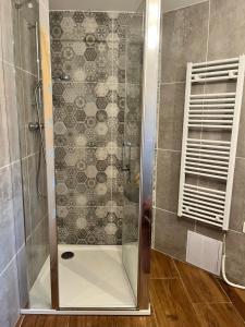 a shower with a glass door in a bathroom at Apartmán Buky in Mladé Buky +10 photos