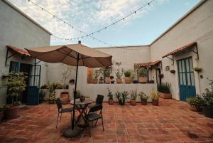 a patio with an umbrella and chairs and plants at Casa Arrayan in Guadalajara
