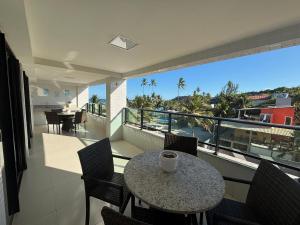 a table on a balcony with a view of the ocean at Flat Gold Sea View - Tabatinga Beach in Conde