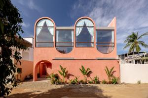 a house with round windows on the side of it at Amplitude Coliving in Brisas de Zicatela