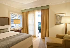 um quarto com uma cama, uma cadeira e uma janela em Four Seasons Residence Club Aviara em Carlsbad