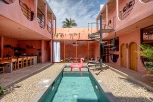 a house with a pool and a pink chair in it at Amplitude Coliving in Brisas de Zicatela
