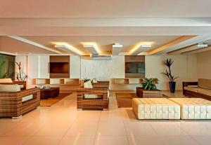 a large living room with couches and a couch and tables at Flat Gold Sea View - Tabatinga Beach in Conde