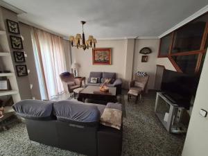 a living room with a couch and a tv at Casa Turistica Termas aparcamiento y desayuno incluido in Mérida