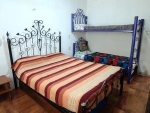 a bedroom with a bed with a striped blanket at La Morada de sus Sueños Caeiro in Bialet Massé +11 photos
